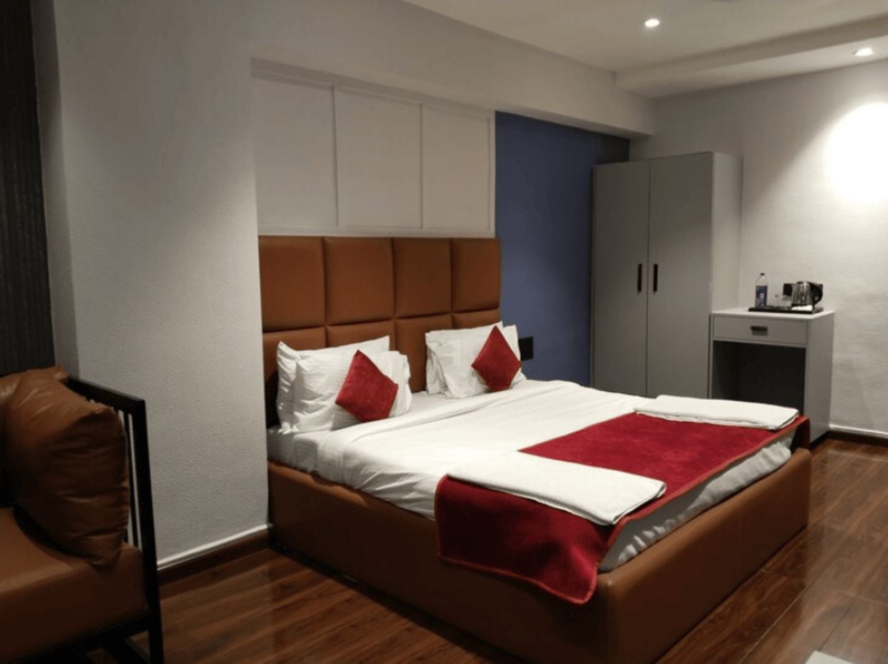 Un dormitorio moderno con una cama grande, un aparador y una zona de estar.