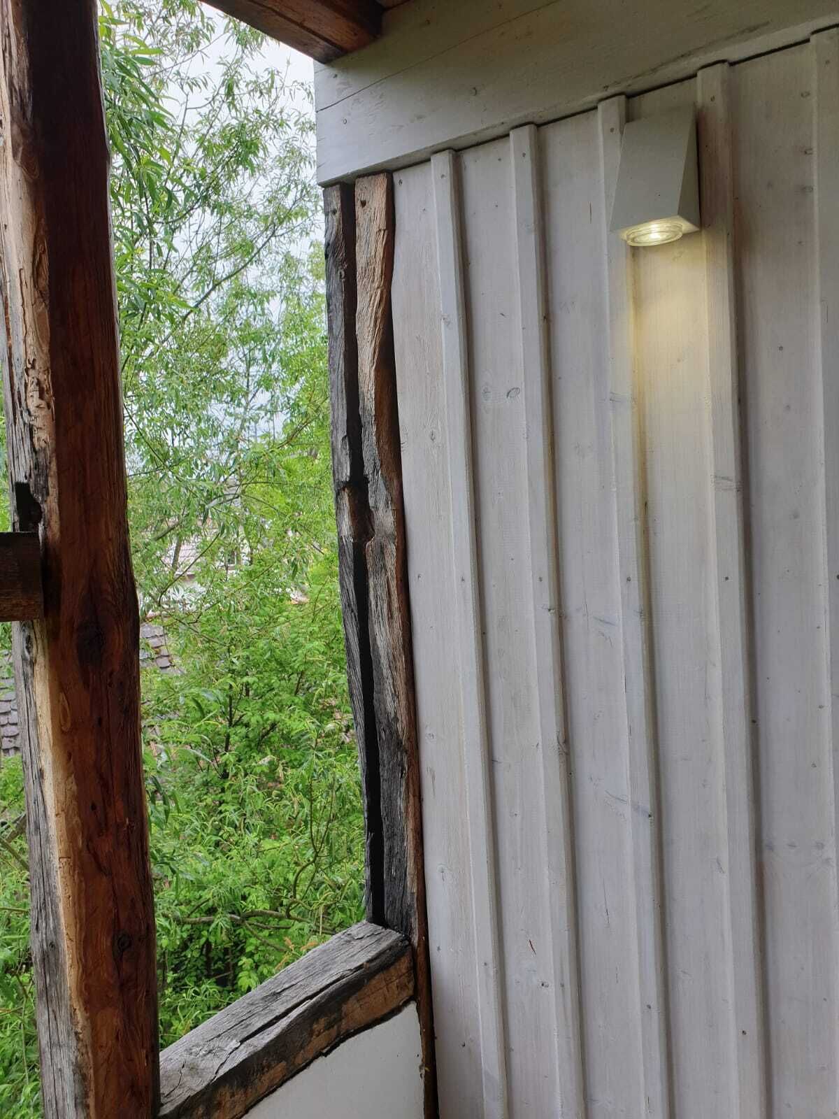 Eine Holzhütte mit weißer Wand und einem Fenster.