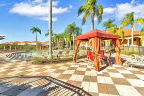 A poolside area with a checkered floor, lounge chairs, and a red pavilion. - Dream Vacation Home With CDC Cleaning Standards! Stunning and Spacioud 6BD Villa Near Disney! #6av350 (Davenport)