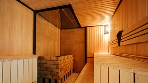 Una sauna con bancos de madera y una pared de ladrillo.