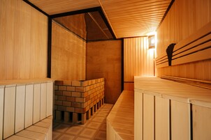 Una sauna con bancos de madera y una pared de ladrillo.