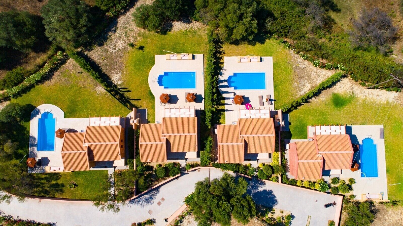 Une vue aérienne d’un complexe hôtelier comprenant plusieurs bâtiments, chacun doté d’une piscine et d’espaces de détente en plein air.