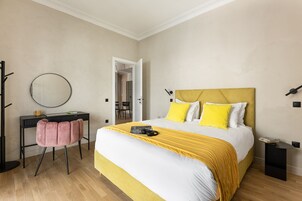 Ένα υπνοδωμάτιο με ένα κρεβάτι, ένα γραφείο, μια καρέκλα και έναν καθρέφτη.