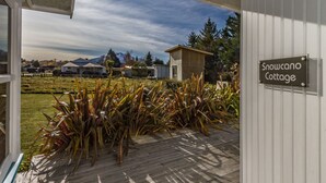 Une terrasse en bois sur laquelle est accrochée une pancarte indiquant : « Snowcano Cottage ».