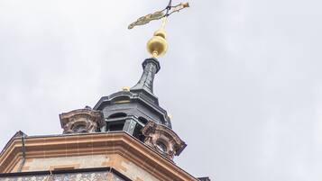 Tejado ornamentado de un edificio, con veleta y un remate esférico.