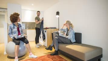 Ein modernes Wohnzimmer mit einer Couch, einem Fitnesstalent und einem kleinen Tisch mit einer Lampe.