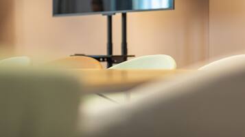 Una vista borrosa de una habitación con televisión sobre un mueble, una cama y una silla.
