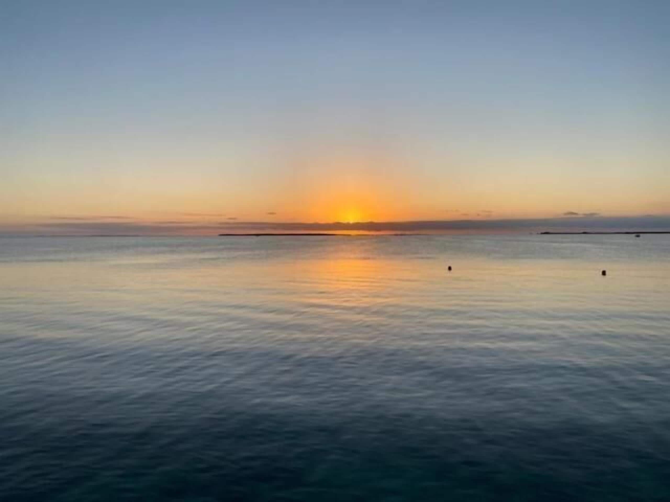 Mar tranquila al atardecer con horizonte despejado.