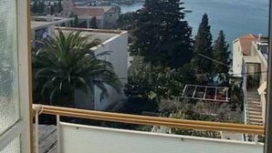 A balcony with a view of a coastal town, buildings, and a clear sky. - Rooms Vinka Tudor (Hvar)
