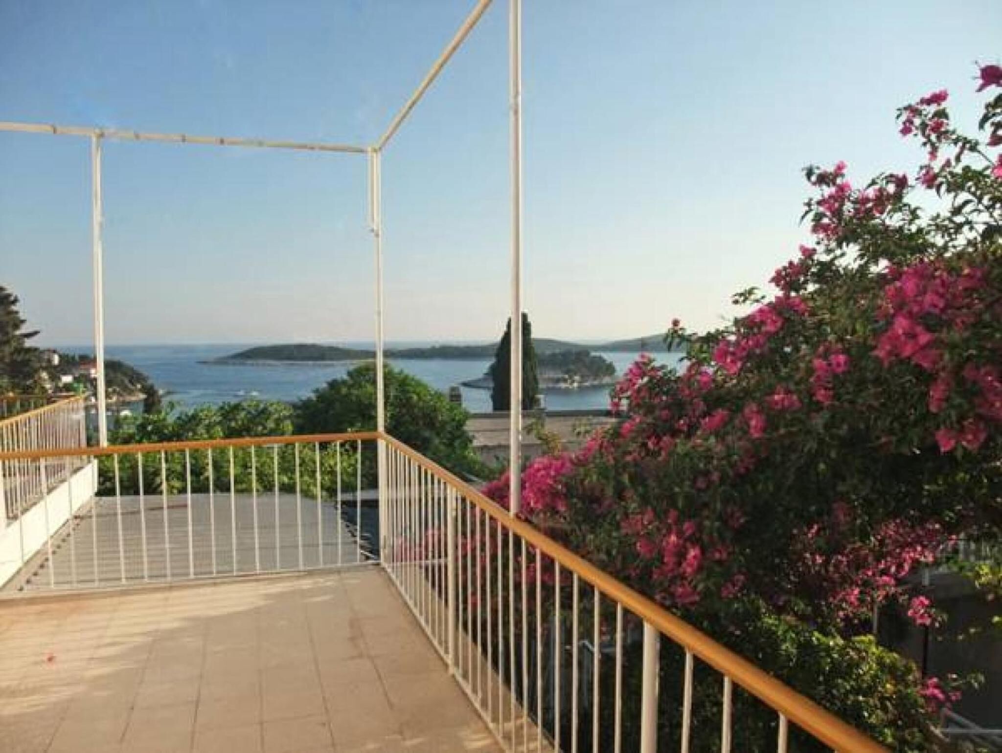 Un balcon avec vue sur la mer et une île lointaine.