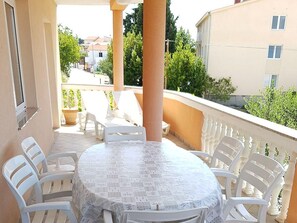 Enjoy a meal or a moment of peace on this balcony with a table for four and comfortable seating.