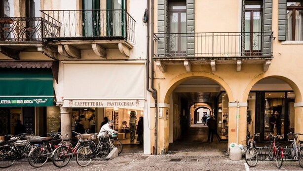 A cobblestone street with a café and a bakery. - MyPlace Piazze di Padova - Studio Balcony with view on "Piazza dei Signori" Square (Padova)