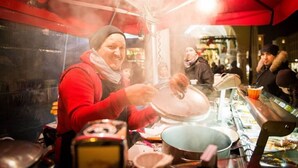 A street food vendor preparing food under a red canopy. - MyPlace Piazze di Padova - Studio Balcony with view on "Piazza dei Signori" Square (Padova)