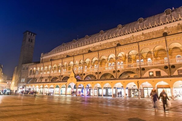 A historic building with multiple arches and a tower, featuring a spacious courtyard. - MyPlace Piazze di Padova - Studio Balcony with view on "Piazza dei Signori" Square (Padova)