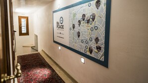 A hallway with a large map on the wall, a wooden door, and a red carpet. - MyPlace Piazze di Padova - Studio Balcony with view on "Piazza dei Signori" Square (Padova)