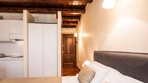 A bedroom with a bed, pillows, a nightstand, and a wooden ceiling. - MyPlace Piazze di Padova - Studio Balcony with view on "Piazza dei Signori" Square (Padova)