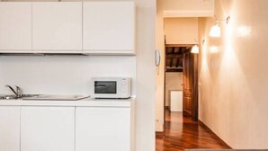 Une cuisine moderne avec des meubles blancs, un four à micro-ondes et un évier.