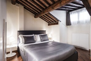 A bedroom with a bed, bedside tables, and a sloped ceiling. - MyPlace Piazze di Padova - C. S. Clemente 1, Attic Apartment (Padova)