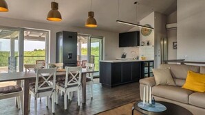 A spacious living area with a dining table, chairs, a sofa, and a kitchen island. - Villa Pomer (Medulin)