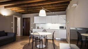 Ein moderner Wohnbereich mit Essplatz, Küche und einer Couch.