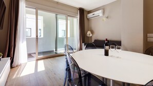 A modern room with a round table, chairs, a bottle of wine, and a glass. - MyPlace - Appartamento Family Deluxe Terrace (Treviso)