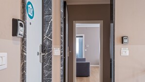 L’entrée d’un hôtel, avec un mur de marbre, une porte portant le numéro « 10 » et un clavier numérique.