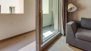 Een moderne woonkamer met een schuifglazen deur naar een badkamer.