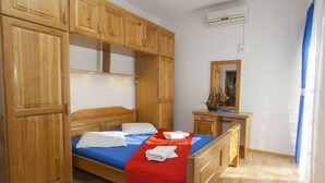 A bedroom with a bed, wooden wardrobe, desk, and mirror. - Lovely studio for 2 persons (Makarska)