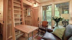 Ein gemütliches Blockhaus-Interieur mit einem Holztisch, einem Ledersofa und einem Sessel.