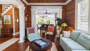 A spacious living room with a wooden ceiling, a dining area with wicker furniture, and a view of the outdoors. - SUNCATCHER~4 Bedroom, 4 Bathroom in Old Town with Pool! (Key West)