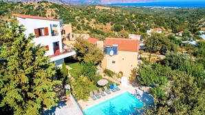 A residential property with a swimming pool, solar panels, and a view of the sea. - Grand View Villa | Heated Pool (Georgioupoli)