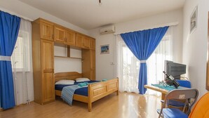 A bedroom with a wooden bed, a desk with a computer, and a chair. - Apartment Almera N2 (Makarska)