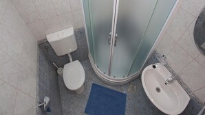 A small bathroom with a toilet, a shower stall, and a sink. - Apartment Almera N2 (Makarska)