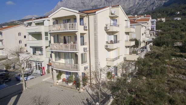 A multi-story hotel with balconies, situated in a mountainous area. - Apartment Almera N2 (Makarska)