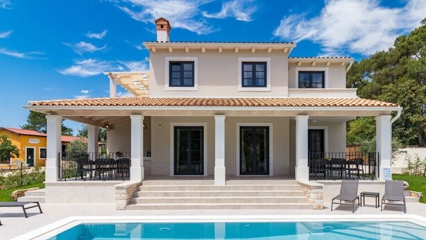A two-story house with a swimming pool, outdoor seating, and a covered patio. - Modernly designed villa located near Pula (Manjadvorci)