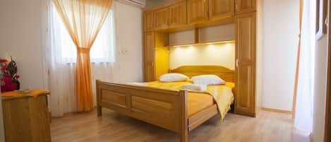 A bedroom with a wooden bed, a nightstand, and a wardrobe.