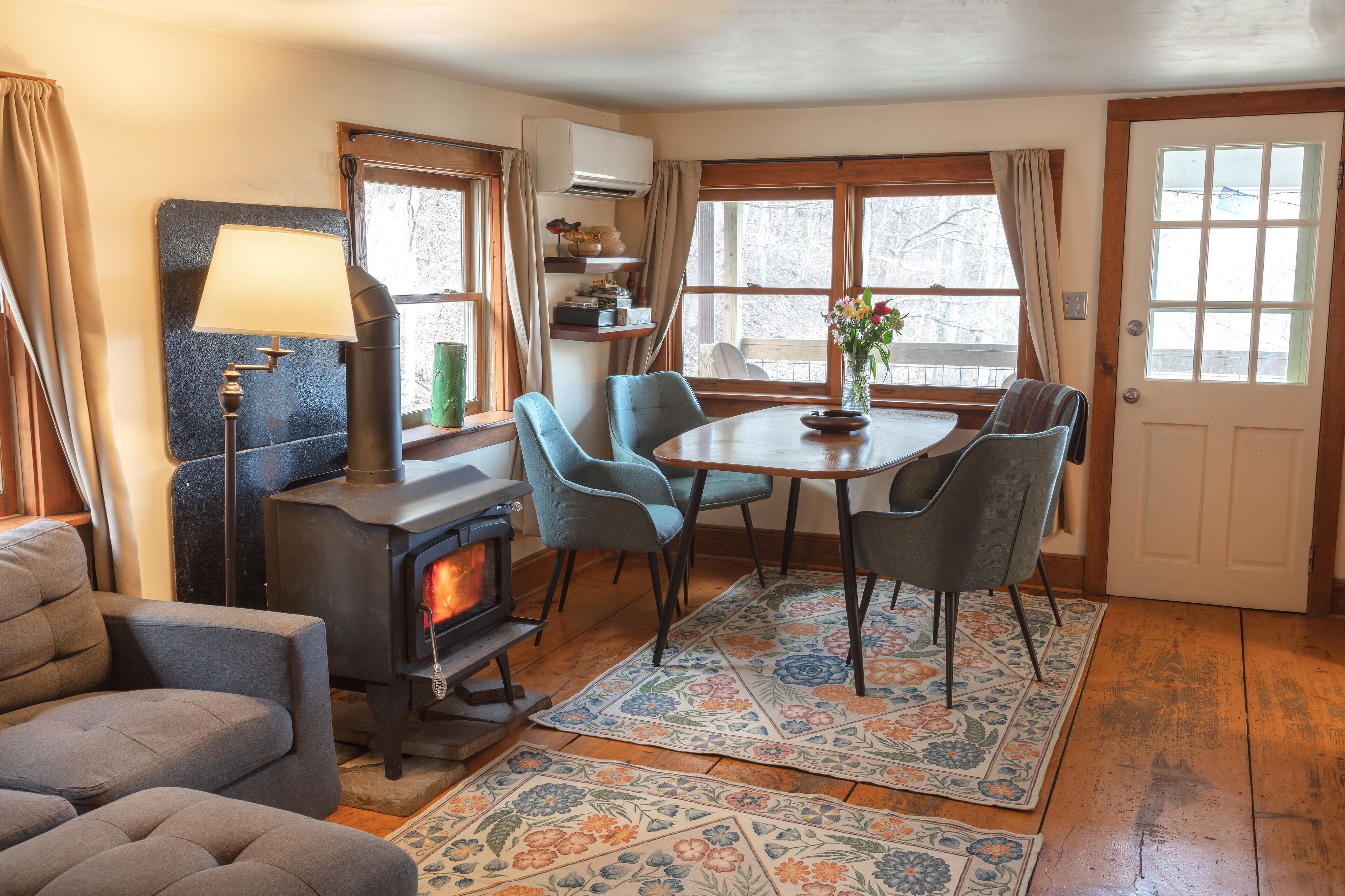 A cozy living room with a fireplace, comfortable seating, and a dining area with a table and chairs.