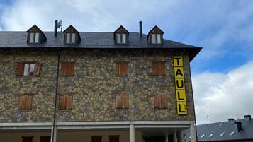 Un edificio de piedra con un letrero que dice "TAULL".