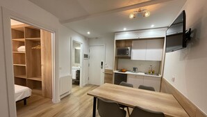 Un espacio habitable compacto con comedor, kitchenette y vestidor.