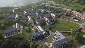 Zona residencial con varios edificios de dos pisos, cada uno con un patio central y una pequeña piscina.