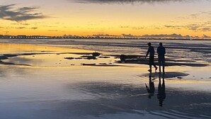 A beach scene with two people walking on the shore. - Private_vacation_home (El Jadida)