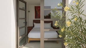 A bedroom with a bed, a nightstand, and a painting on the wall. - Private_vacation_home (El Jadida)