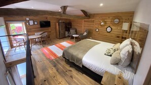 Quarto de cabana de madeira aconchegante, com uma cama, uma mesinha e uma cadeira.