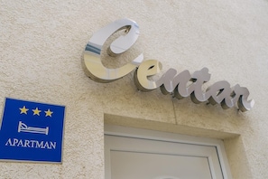 A sign with the word "Center" and a blue sign below it with stars and the word "APARTMAN".
