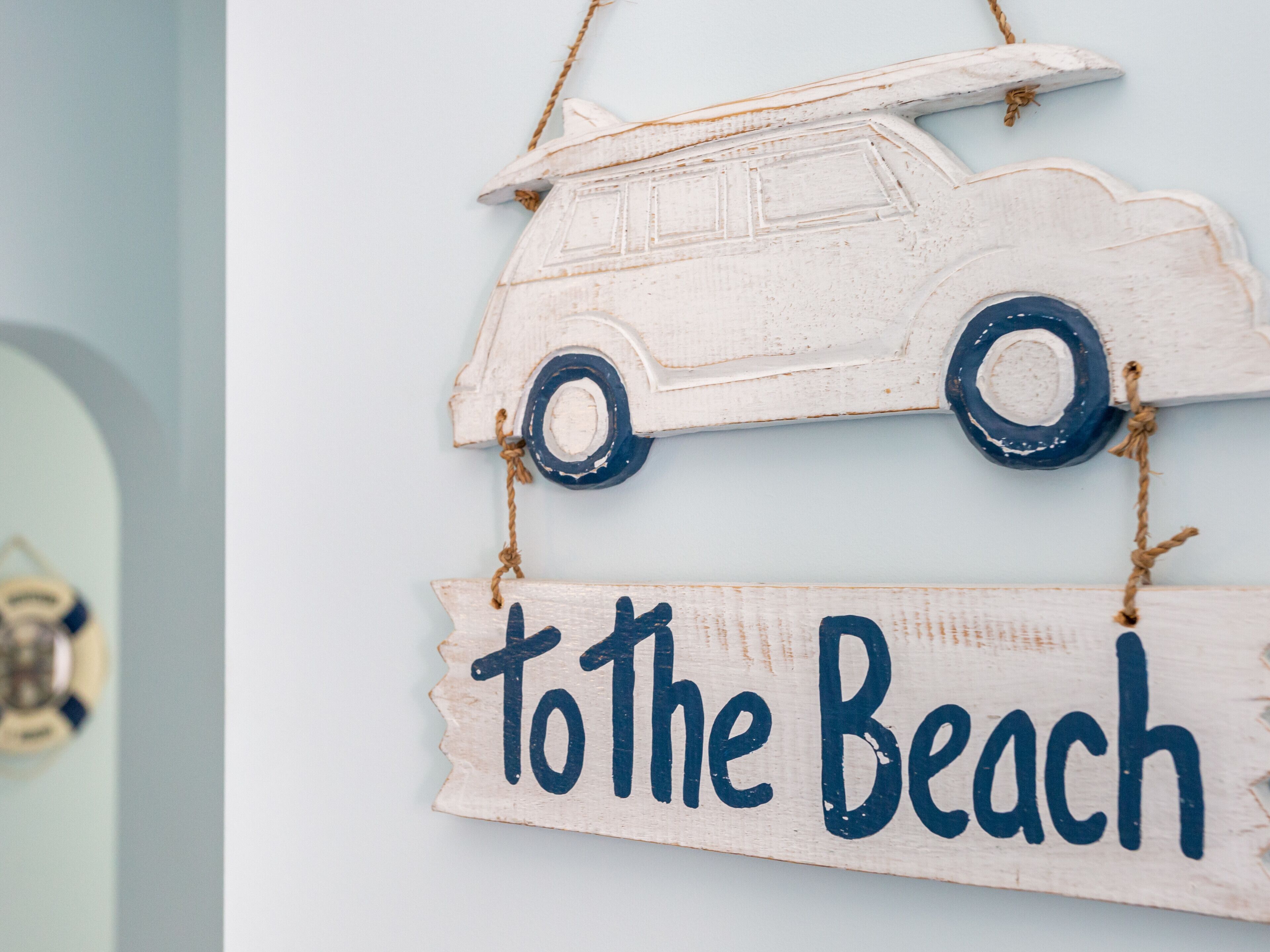Un panneau en bois représentant une voiture et portant l’inscription « Vers la plage ».