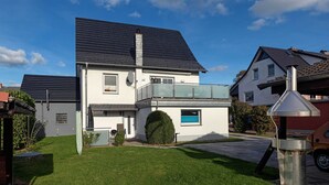 A modern two-story house with a balcony, a satellite dish, and a chimney. - Apt. Dwarslöper - Peaceful holiday apartment in Kirchdorf in the owner's house. (Insel Poel / OT Kirchdorf)