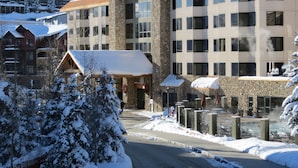 A hotel with a stone facade, multiple windows, and a sign reading "The Grand Inn".