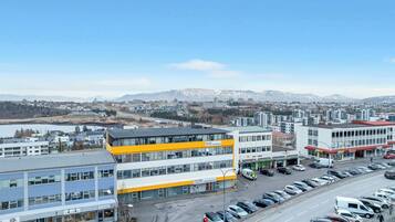 A multi-story building with 'Iceland Comfort Apartments' signage, a Subway restaurant, and a parking lot with cars.