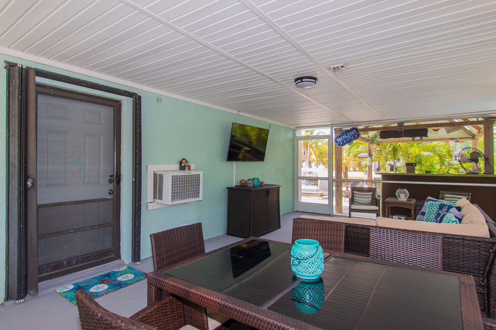 A covered patio area with a dining table, chairs, and a seating area.
