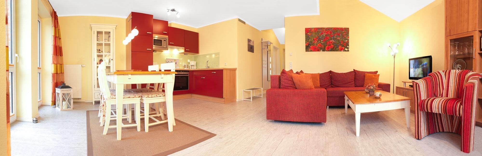 A modern living room with a sofa, coffee table, and a dining area with a table and chairs.